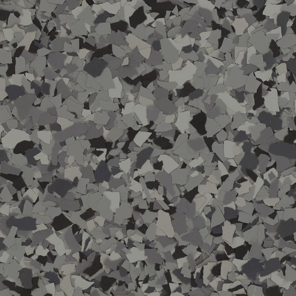 Abstract pattern of variously sized, irregular gray and black flakes, creating a textured and monochromatic surface. No recognizable landmarks or buildings.